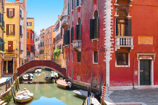 View of the  narrow canal with colorful old houses in Venice on a sunny day, Italy.