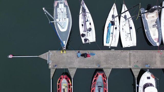 Overhead aerial shot of marina pier with colorful motorboats