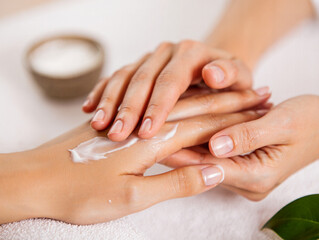 Fototapeta premium Editorial Close Up of Specialist Massaging Client Hands with Moisturizing White Cream