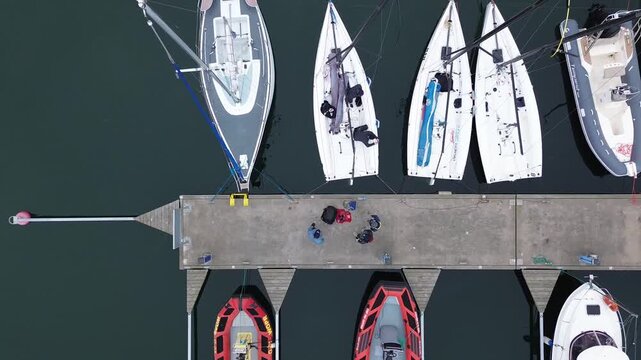 Drone perspective of luxury yachts and speedboats at concrete pier