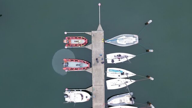 Drone perspective of luxury yachts and speedboats at concrete pier