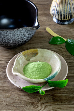 Matcha fine powdered green tea on wooden background.