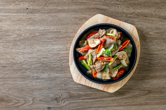 Hot plate of oyster sauce beef on a wooden table.