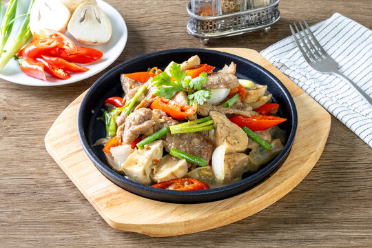 Hot plate of oyster sauce beef on a wooden table.