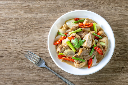 Saut&eacute; the meat in oil in a white plate on a wooden table.