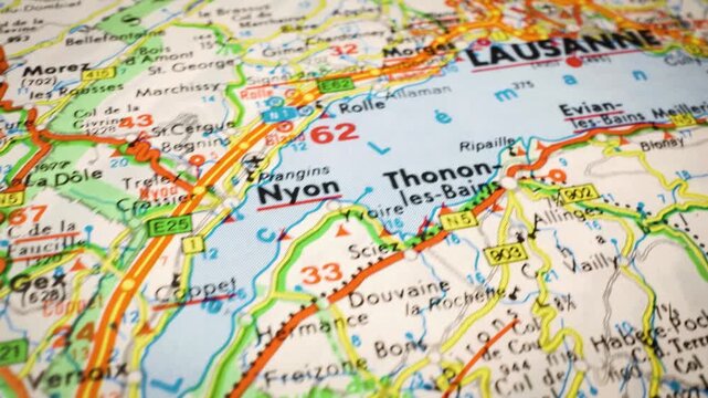 Sliding camera movement over Swiss road map highlighting route from Geneva to Lausanne, travel navigation concept