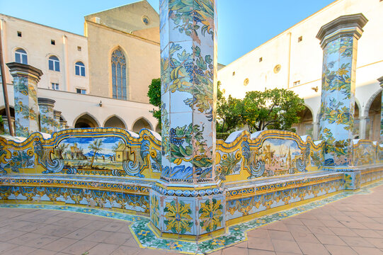 The famous Cloister of Santa Chiara with ornate ceramic tiled columns and benches in the historic center of Naples, Italy