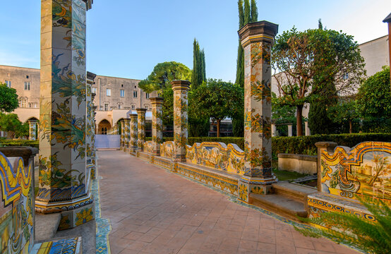 The famous Cloister of Santa Chiara with ornate ceramic tiled columns and benches in the historic center of Naples, Italy