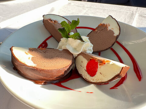 Chocolate covered spumoni slices with whipped cream and mint