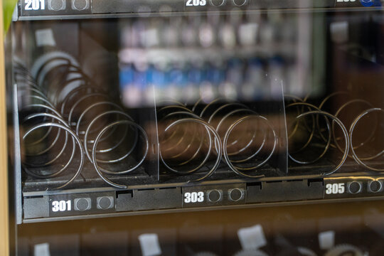 Empty spiral mechanisms inside a modern vending machine, highlighting the absence of products and symbolizing out-of-stock inventory, business challenges, or consumer demand.