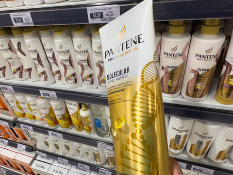 BELO HORIZONTE, MG, BRAZIL, MAY, 15, 2026 A hand holding a Pantene Pro-V Science hair care product in a store aisle with various beauty products on shelves