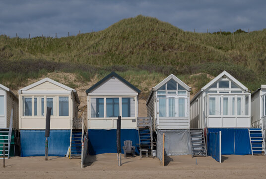 row of small wooden white beach cabins of huts, Zeeland, Netherlands