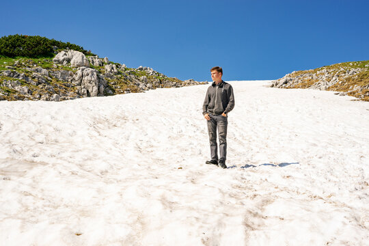 Austria limestone mountains Dachstein. Mountain view of Hallstatter lake.  Young guy stands on an imperishable glacier in the summer