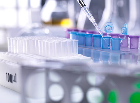 Pipetting DNA sample into vial in a laboratory