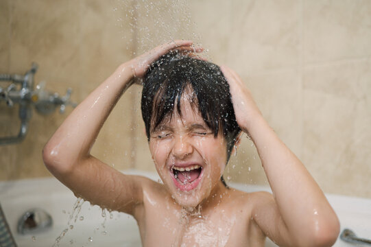 Child enjoying a fun shower in a bathroom with water splashing