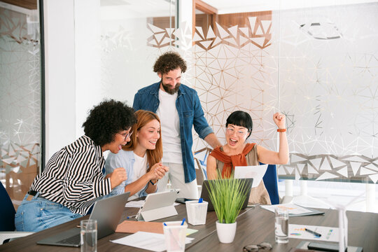 Team celebrating business achievement together in office meeting