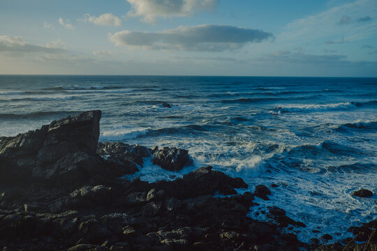 Dramatic rocky coastline and ocean waves in New Zealand