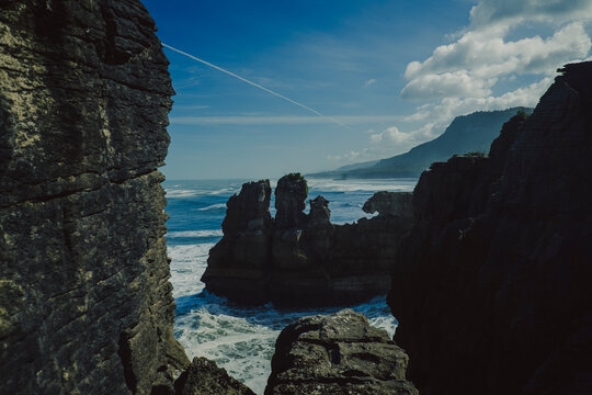Dramatic rocky coastline and ocean waves in New Zealand