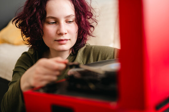 Music lover playing vinyl on a vintage record player indoors