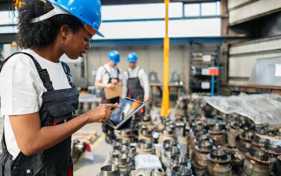 Engineer using digital tablet for quality control in manufacturing