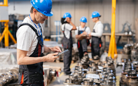 Engineer using digital tablet for quality control in a factory