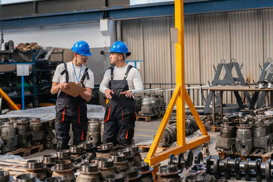 Engineer discussing manufacturing process in industrial factory