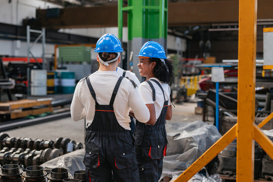 Colleagues discussing manufacturing technology in a workshop