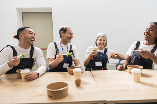 Happy workers enjoying lunch break at the factory cafeteria