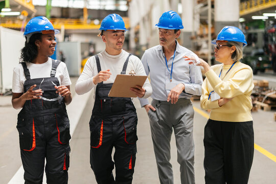 Engineering team walking and discussing production in the factory