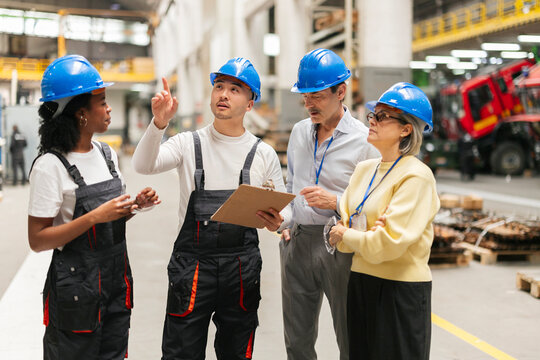 Engineers and workers discussing production in a factory