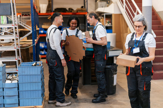 Warehouse staff in uniform processing cardboard box for delivery