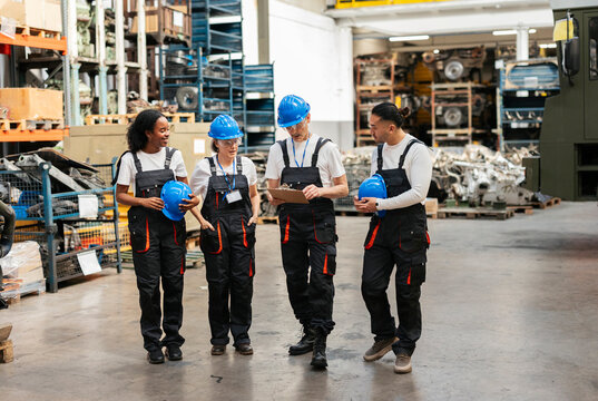 Workers discussing manufacturing process in a factory