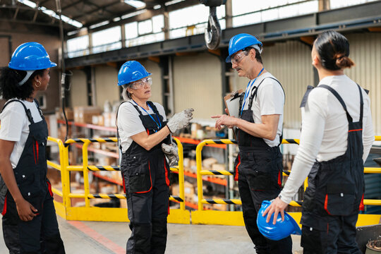 Factory workers discussing engineering project indoors