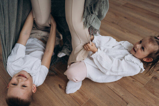 Cheerful family having fun and playing on wooden floor at home