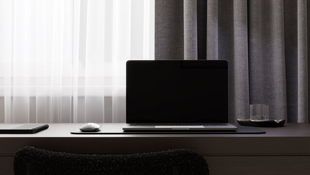 Modern laptop mockup on a dark desk indoors with copy space