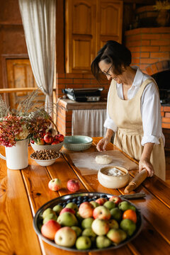 Baker preparing homemade dough with apples on a veranda