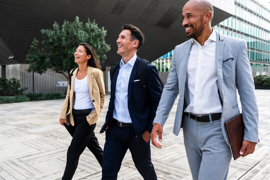Smiling business team walking together in financial district
