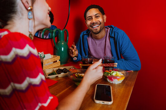 Couple eating sushi dinner on a date at restaurant