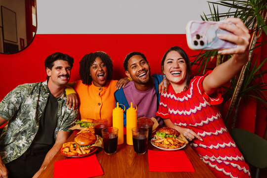 Friends taking selfie during burger dinner at restaurant