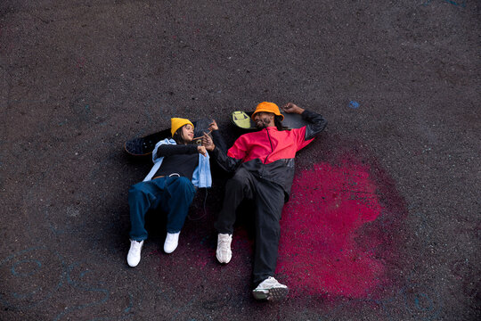 Friendship and laughter on asphalt ground with skateboard