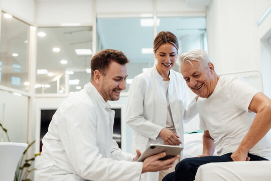 Doctors consulting with a patient in a medical office using a tablet
