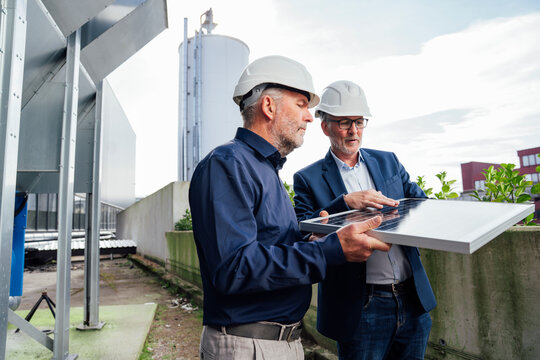 Engineers discussing solar panel project outdoors