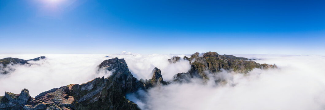 Aerial of Pico do Arieiro volcanic peaks above clouds in Madeira