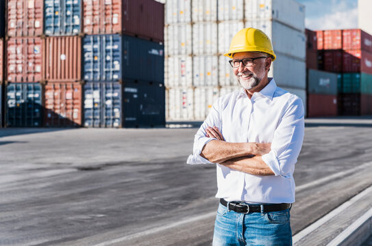Smiling logistics manager with hardhat at commercial dock