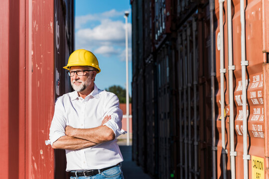 Confident manager standing at outdoor shipping container terminal