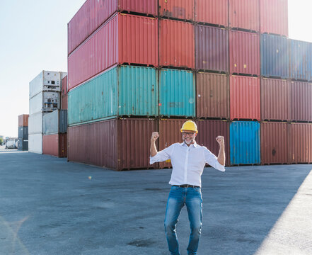 Happy manager celebrating success at outdoor shipping container port