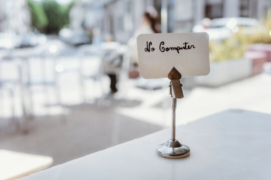 No computer sign on a table at a sunny outdoor cafe terrace