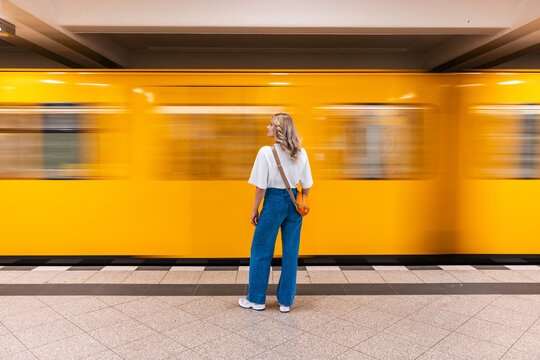 Woman commuter waiting at Berlin underground station as train passes