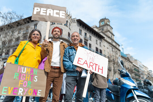 Smiling family holding protest sign for peace in Barcelona
