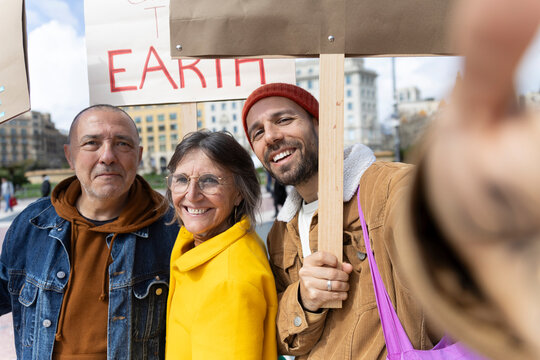 Smiling activist family taking selfie at urban protest in Barcelona